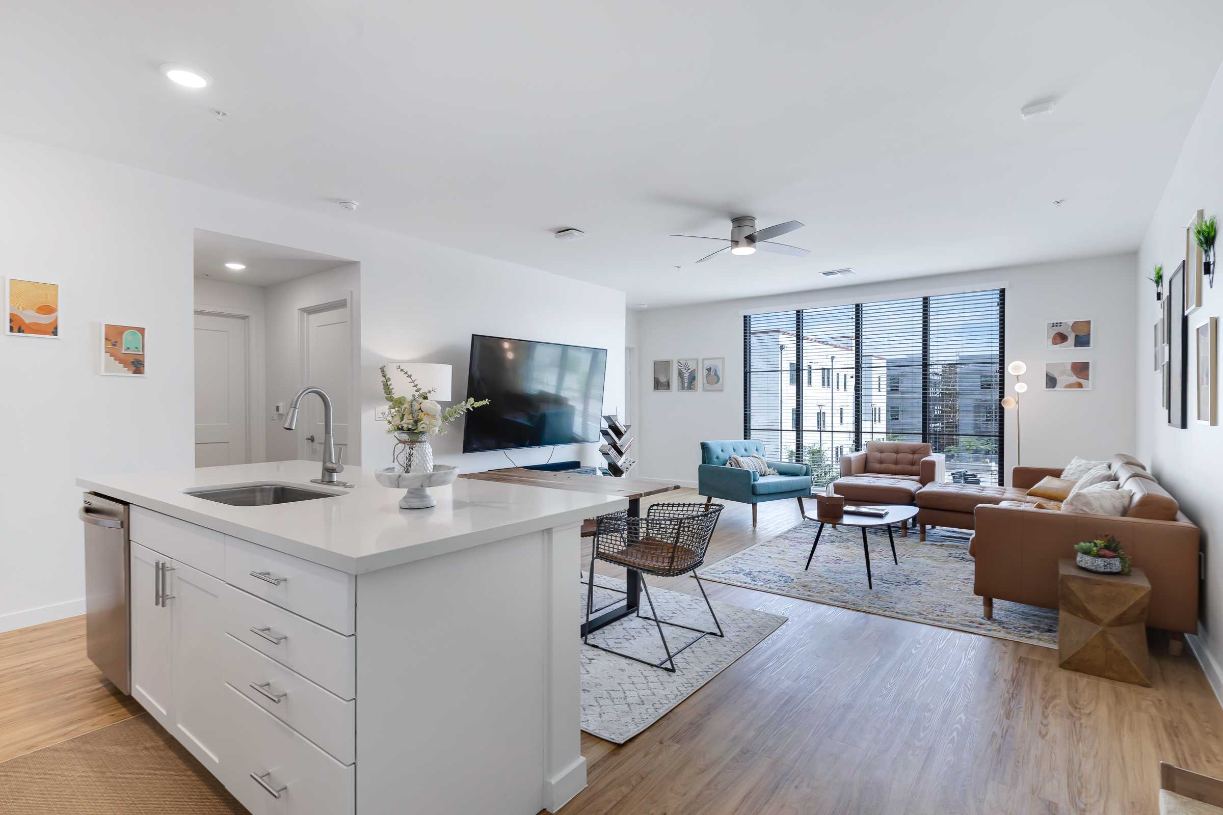 Beautiful modern apartment living space with bright white walls, contemporary furniture, and wood-style flooring